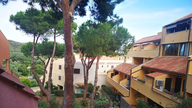 A residential building with multiple balconies, surrounded by trees and greenery. - Apartment in La Maddalena (La Maddalena)