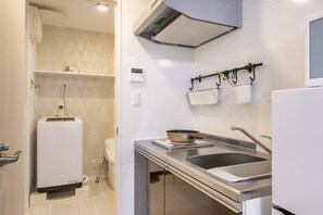 A modern kitchen with a built-in oven, a sink, and a stove. - Real Waseda (Tokyo)