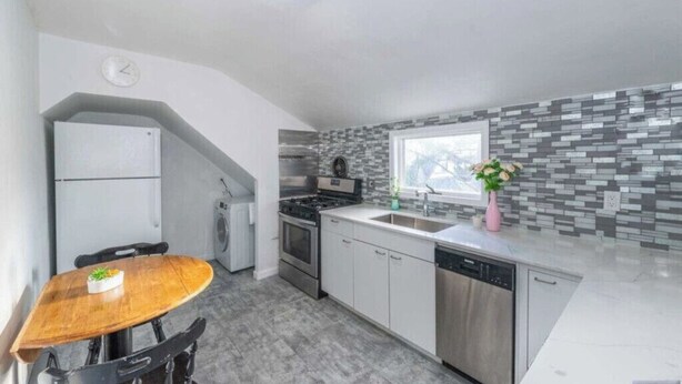 A modern kitchen with white cabinets, a stainless steel dishwasher, and a tiled backsplash. - Cozy & Quiet 2 Bed Apt 20 Minutes to NYC (Fort Lee)