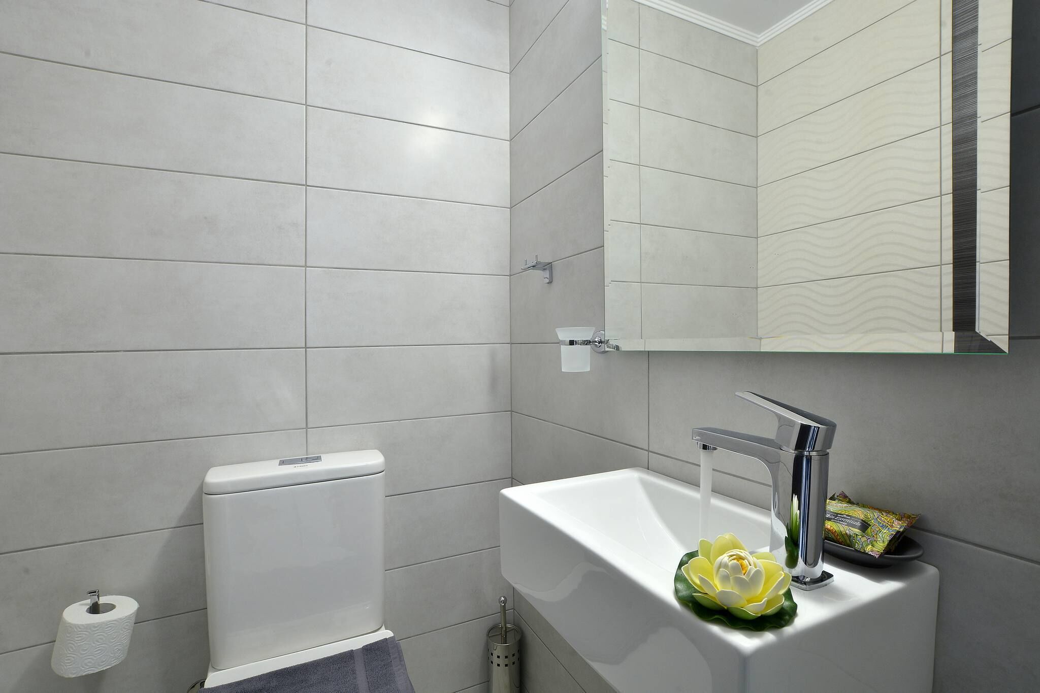 Un baño moderno con inodoro, lavabo y espejo.