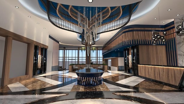 Un hall d’entrée moderne avec une table ronde centrale, un escalier en colimaçon et un comptoir d’accueil.