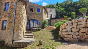 A stone building with a rustic exterior, a set of stone steps leading to a door, and a stone wall in the foreground. - Mas de Saudon (Soyans Auvergne-Rhône-Alpes)
