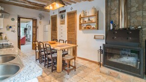 A rustic kitchen with a stone floor, wooden furniture, and a built-in wood stove. - Cortijo Don Simon, ideal for families and friends (pet friendly) (Cabra)