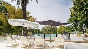 Outdoor seating with umbrellas, a pool, and a fenced area. - Cortijo Don Simon, ideal for families and friends (pet friendly) (Cabra)