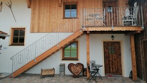 En træbygning med balkon, trappe og pejse med hjerteform.