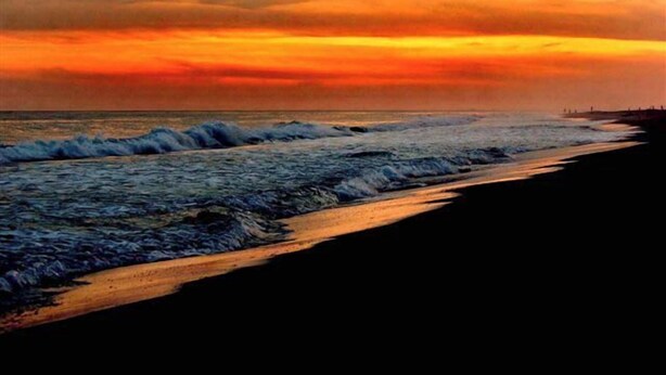 A beach with waves and a sunset. - Coral Breeze (Fort Morgan)