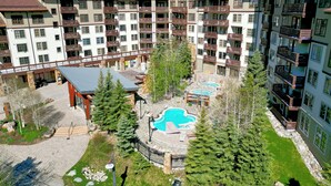 A multi-story hotel with balconies, a pool area, and a covered patio.