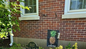 A brick building with a 'Welcome' sign and a 'Meadow Lark Ave' address sign. - Convenient to every event that Louisville hosts! (Audubon Park)