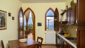 Une cuisine avec coin repas, dotée de meubles en bois, d’une cuisinière et offrant une vue sur l’extérieur.