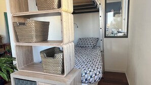 A compact room with a bed, a mirror, and a built-in storage unit with multiple compartments. - Loft 80m2 top floor 100m beach & center Bandol (Bandol)