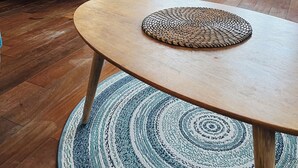 A room with a round wooden table, a blue chair, and a woven placemat. There are potted plants, a bookshelf, and a framed picture on the wall. - Loft 80m2 top floor 100m beach & center Bandol (Bandol)