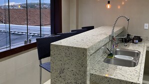Een moderne keuken met een granieten werkblad, een roestvrijstalen spoelbak en hanglampen.