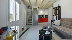 A modern kitchen with a red cabinet, a stainless steel refrigerator, and a staircase leading to an upper level. - Villa Bratou Terra (Corfu)