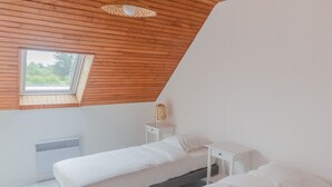 A bedroom with two beds, a skylight, and a white wall. - A stone's throw from the beaches, house with large enclosed garden (Cléder)