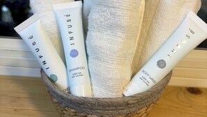 Ein geflochtener Korb mit weißen Handtüchern und Körperpflegeprodukten.
