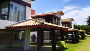 Una casa moderna a due piani con tetto in tegole e un patio coperto.