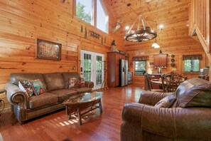 A cozy cabin interior with a wooden interior, a dining area, and a kitchen. - Smoky Lake Retreat - Luxury Family Cabin (Sevierville)