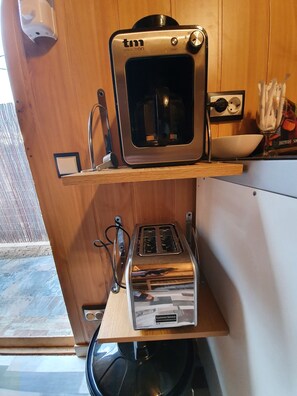 Eine kleine Küchenzeile mit Toaster, kleinem Backofen und Spüle.