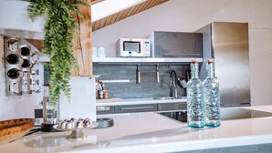 Une cuisine moderne équipée d’un réfrigérateur en acier inoxydable, d’un four à micro-ondes et d’un évier.