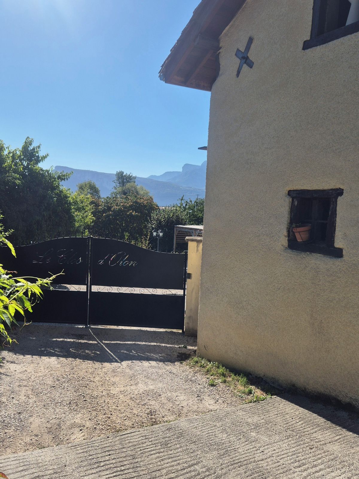 Un bâtiment doté d’un mur extérieur à la texture particulière, d’une petite fenêtre et d’un portail agrémenté d’éléments décoratifs.