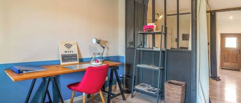 A room with a desk, chair, and a bookshelf.