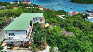 Una propiedad costera con una casa grande, una piscina y vista al mar con barcos.