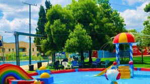 Parque acuático con piscina, toboganes y estructuras de juegos.