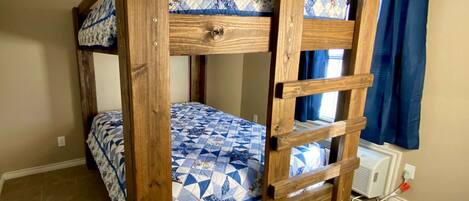 Un lit superposé avec une structure en bois et une literie à motifs bleus et blancs.
