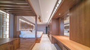 Ein modernes Hotelzimmer mit Holzboden, einem großen Bett, einem Schreibtisch und Blick auf die Stadt.