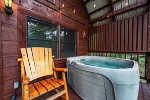 Eine Holzterrasse mit Whirlpool und einem Holzstuhl.