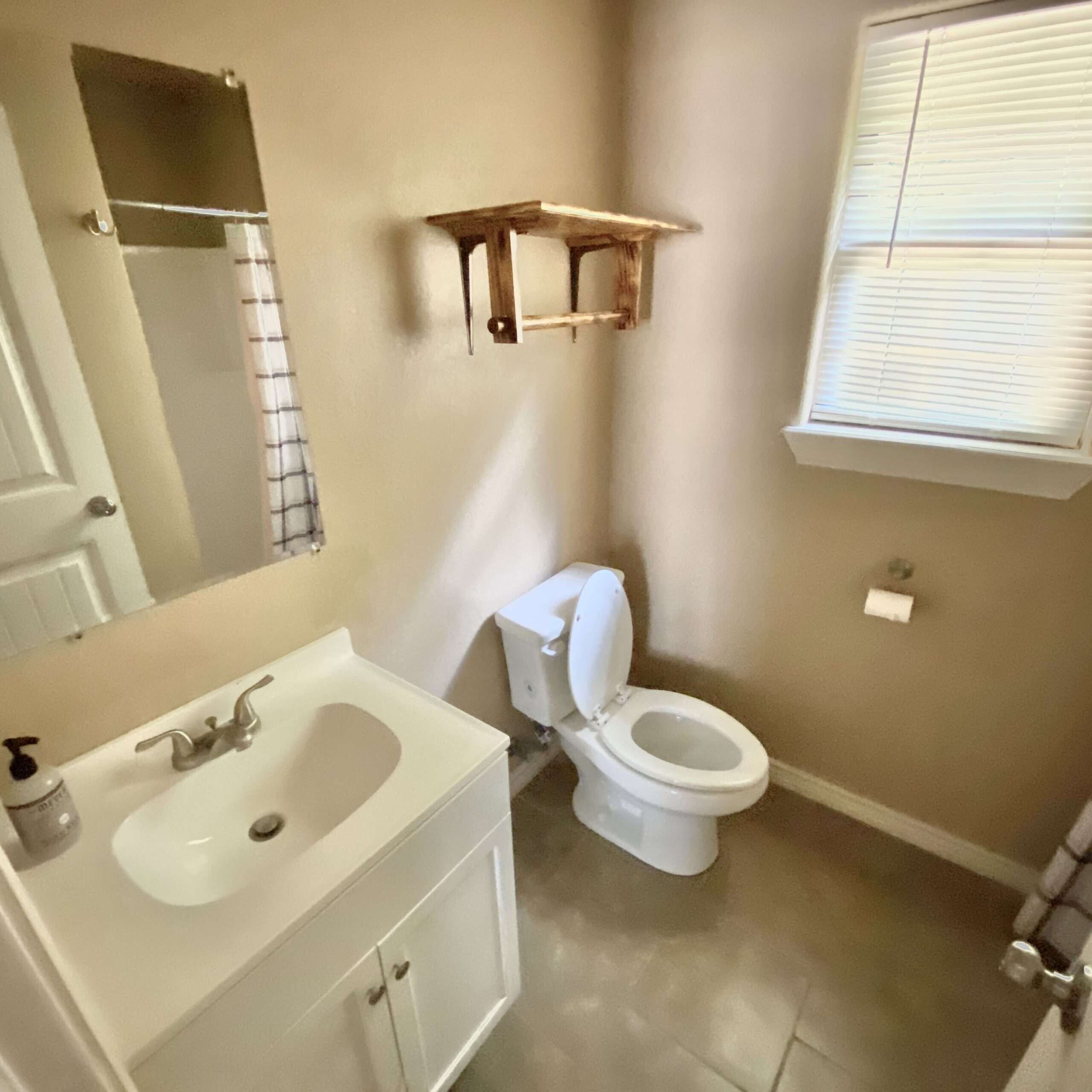 Un bagno con lavandino, servizi igienici e specchio.
