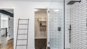 Ein modernes Badezimmer mit Dusche, Glastür und einer Holzleiter.