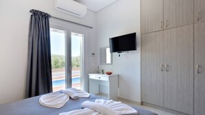 A modern hotel room with a bed, a desk, a TV, and a wardrobe.