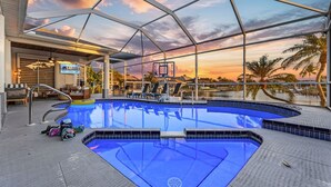 Ein Pool mit Glasdach, umgeben von Liegestühlen und einem Schild mit der Aufschrift 'The Lodge'.