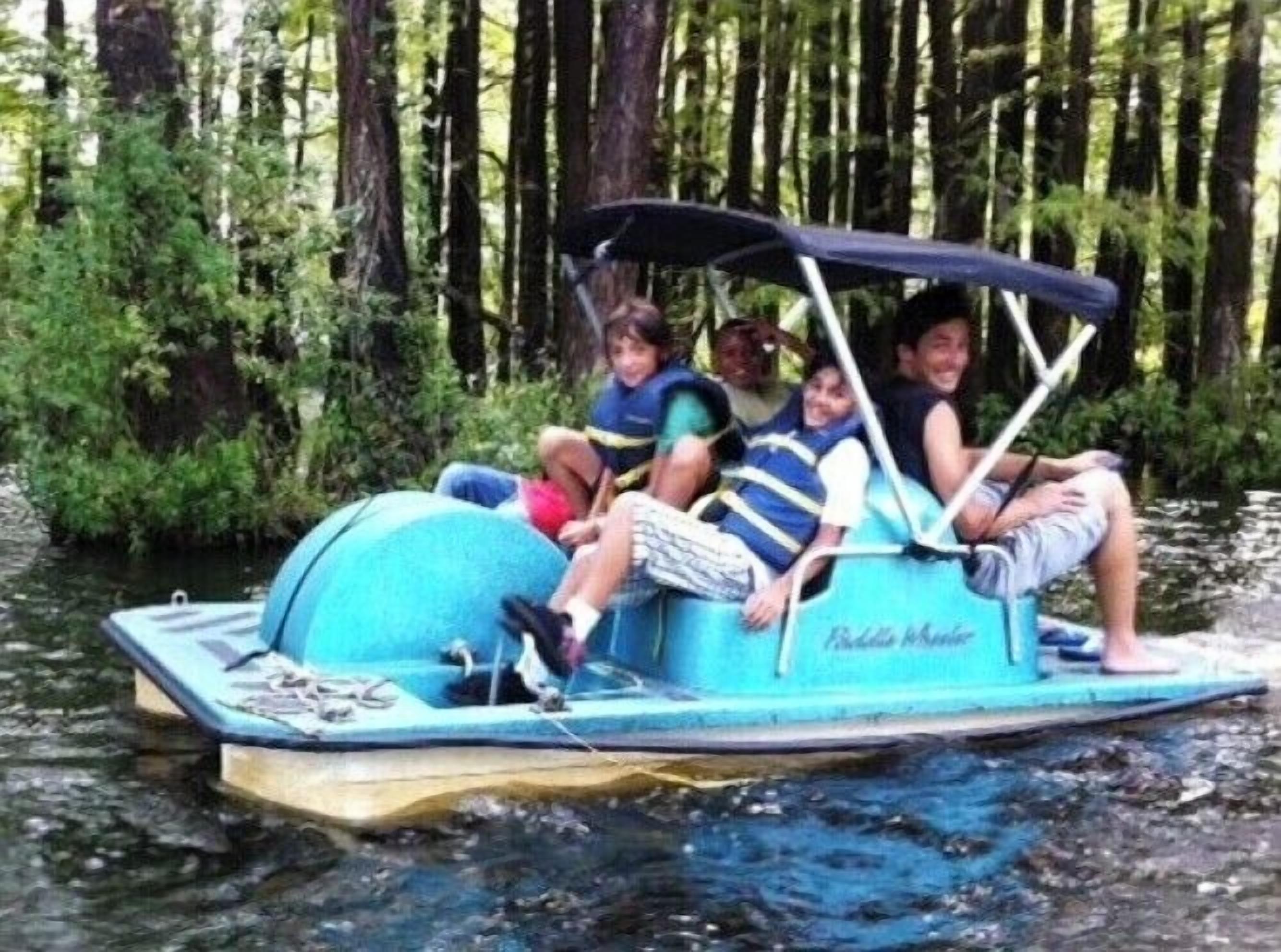 A small boat with a canopy, carrying several passengers.