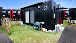 A black container with the number 53, a small table, and air conditioning units. - HOTEL R9 The Yard Miyakojima (Miyakojima)