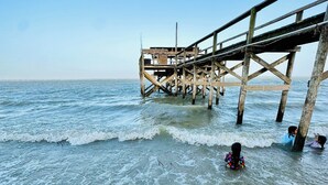 Un muelle de madera se adentra en aguas tranquilas bajo un cielo despejado.