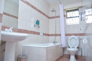 A bathroom with a sink, bathtub, toilet, and shower. - Homes by Della (Nairobi)
