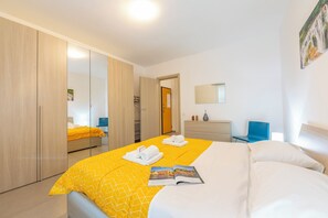 Een hotelkamer met een bed, een kledingkast, een bureau en een stoel.