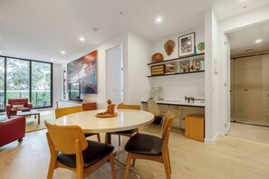 A modern dining area with a round table, chairs, and a large window.
