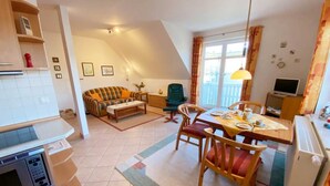 A compact living space with a kitchenette, a dining area, and a sofa.