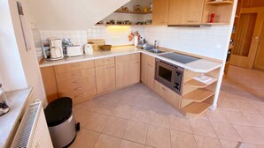 A compact kitchen with wooden cabinets, a built-in oven, and a sink.
