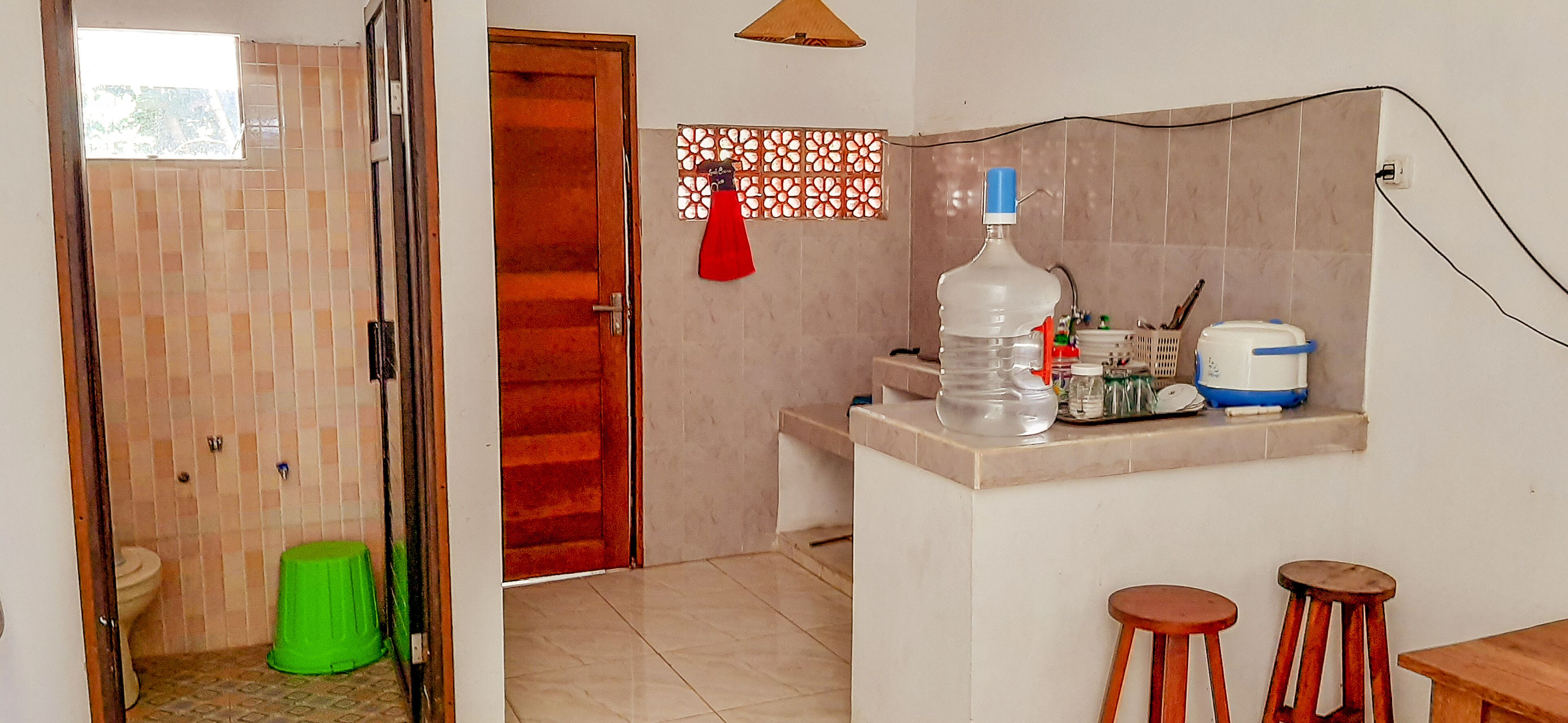 Un bagno con il water, un cestino verde e una zona doccia.