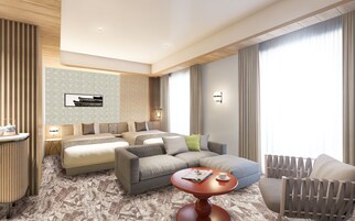 Una habitación de hotel moderna con una cama grande, un sofá, una mesita redonda y una silla.