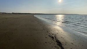 A beach with a clear sky and the sun shining.