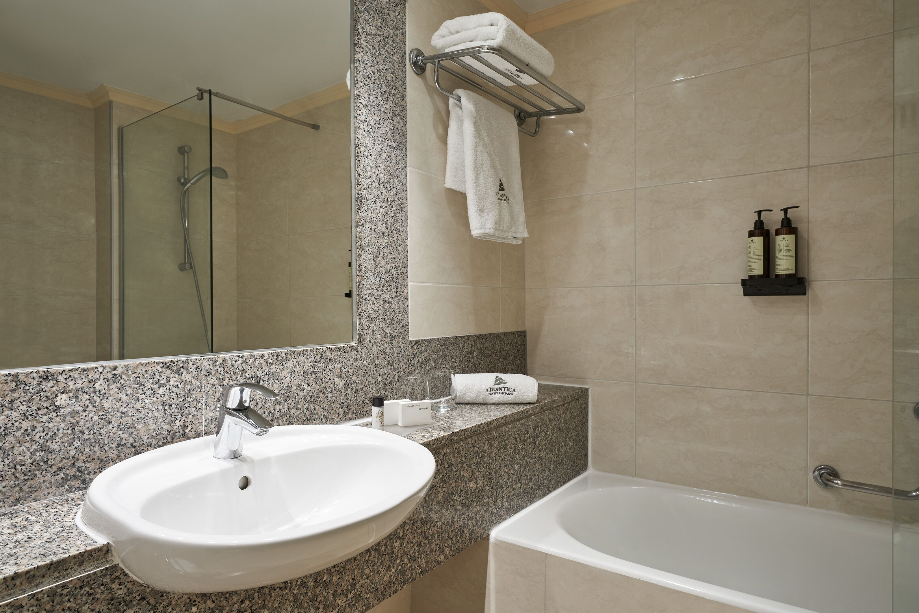 Un baño con lavabo, espejo, ducha y bañera.