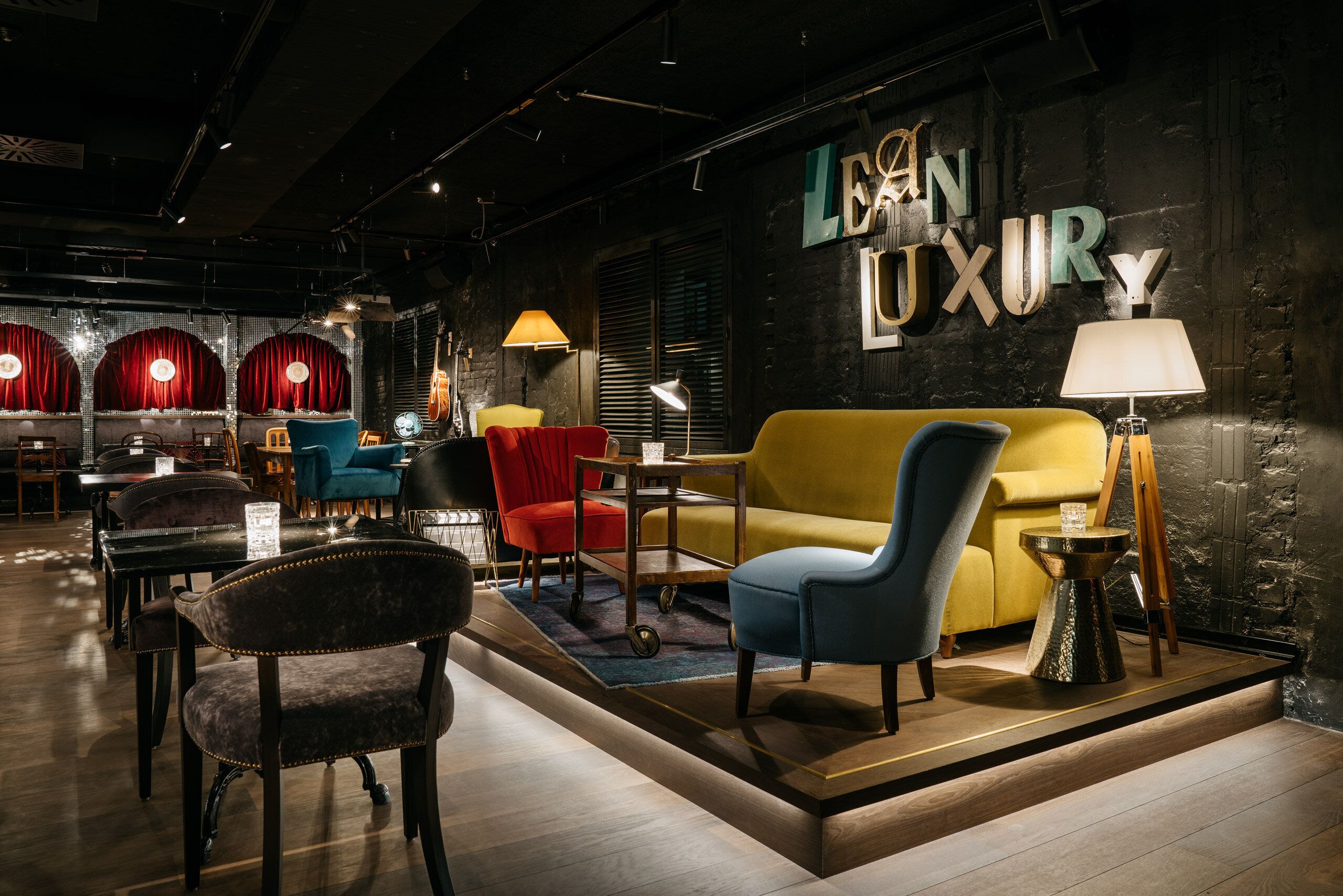 A modern interior with a sofa, chairs, a lamp, and a sign reading 'LEON LUXURY'.