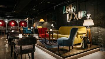 A modern interior with a sofa, chairs, a lamp, and a sign reading 'LEON LUXURY'.