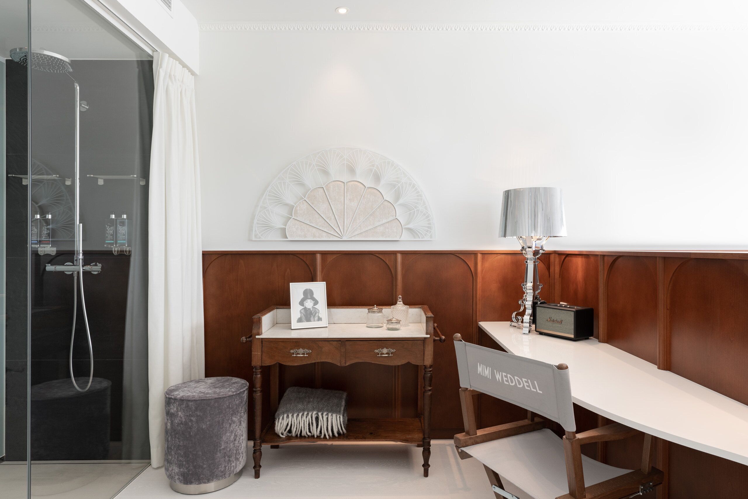 A modern bathroom with a shower, vanity, and a decorative wall piece.