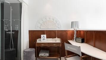 A modern bathroom with a shower, vanity, and a decorative wall piece.